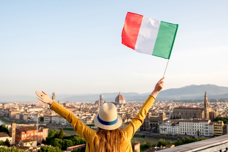 61797217 jeune femme voyageant agitant un drapeau italien sur le vieux fond de la ville de florence dans la